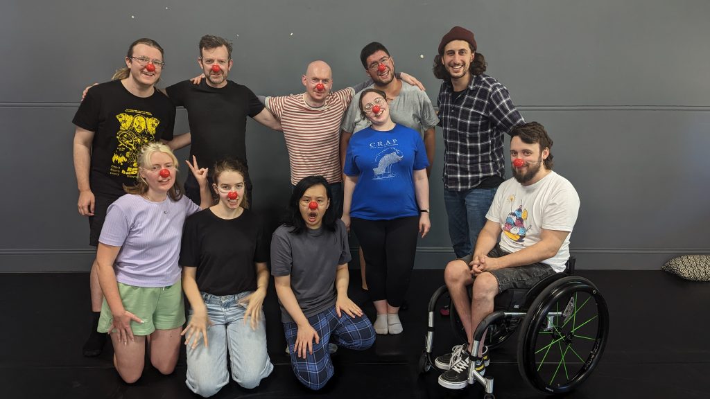 8 people with clown noses, pose for a post workshop picture